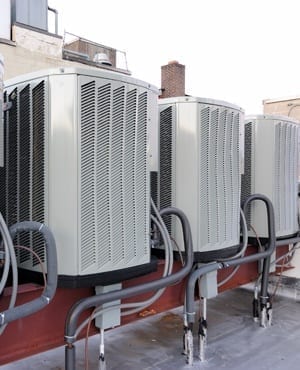 A row of air conditioning units on a rooftop.